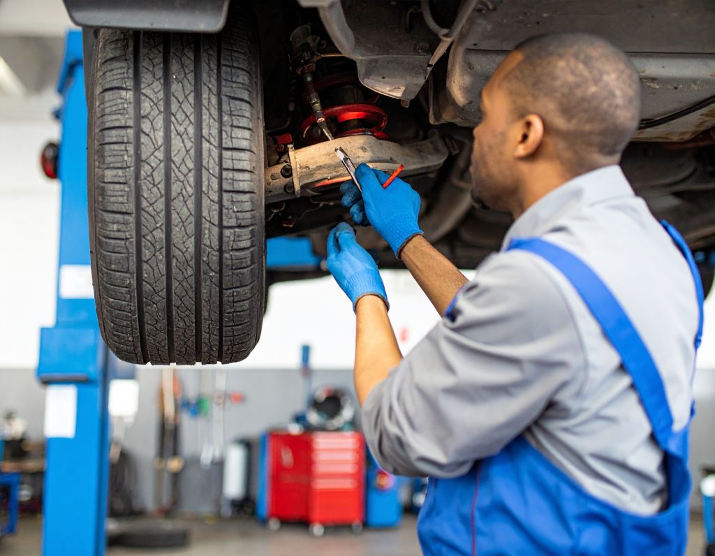 Firefly_Hyper-realistic close-up of an African male technician in clean blue overalls repairi 208526 - Carbon Car Care – Driving Africa’s automotive market Suspension Repair in Malawi